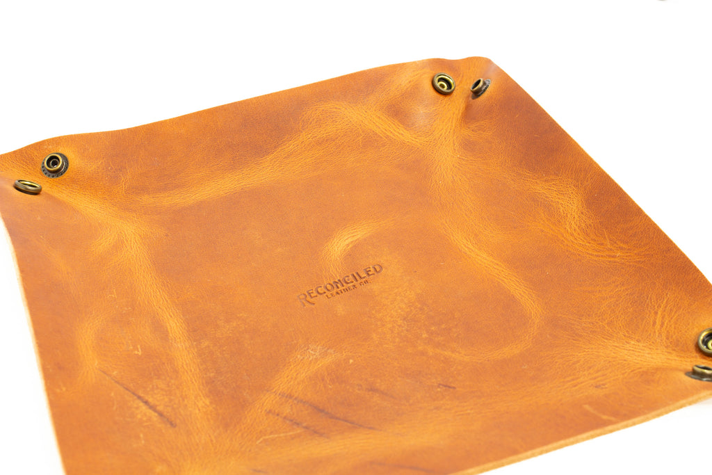 Brown leather pouch with gold accents on a white background