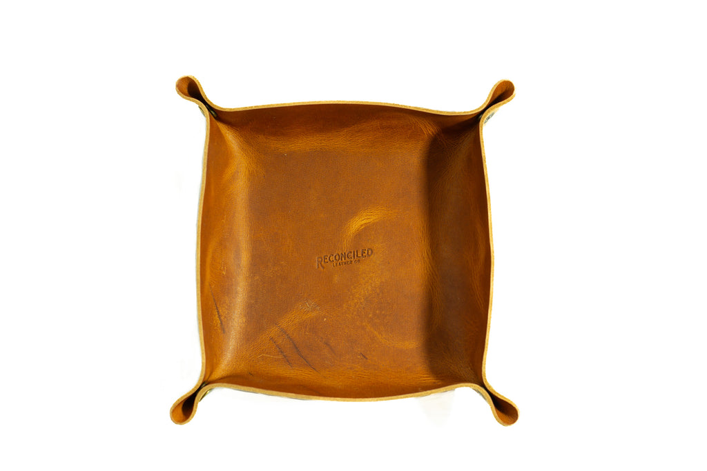 brown full grain leather catchall dice tray with brass snaps on white background.