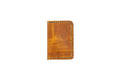 brown full grain leather minimalist wallet hand stitched with blue thread on white background.
